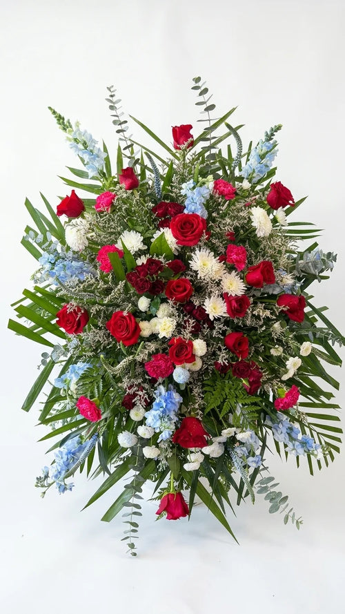 Blue & Red Standing Spray, hand-arranged by Florent Floral for same-day sympathy flower delivery in Newmarket Ontario